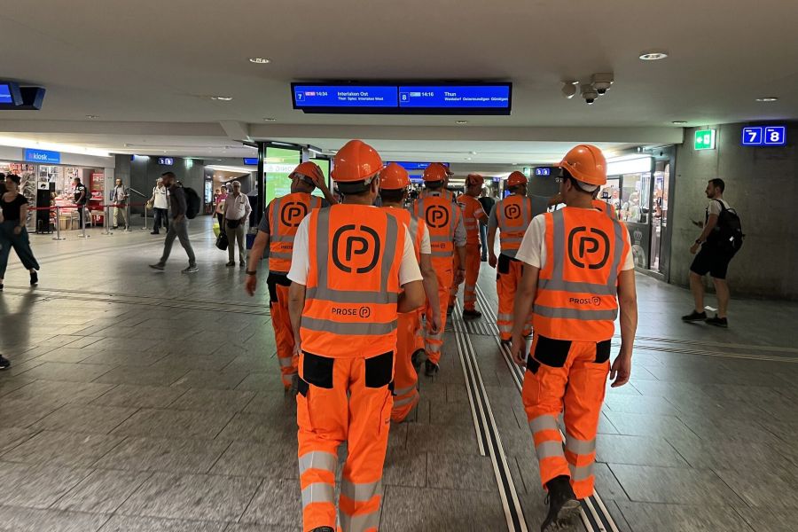 PROSE engineers in high-visibility safety clothing walking through a railway station during a site visit.