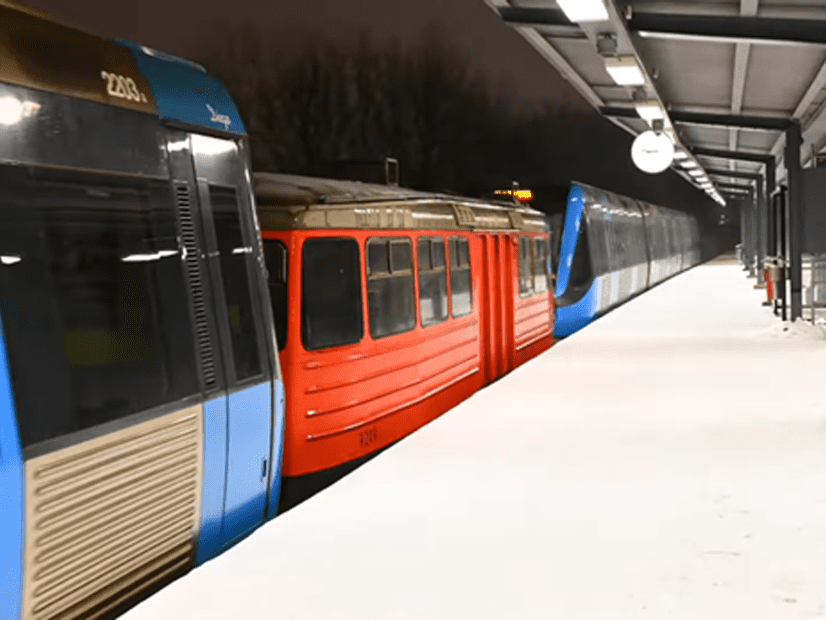 Blue and red trains at a snowy outdoor station platform at night, illustrating rail coupler upgrade and electrical interface integration for snowblower wagon type B257