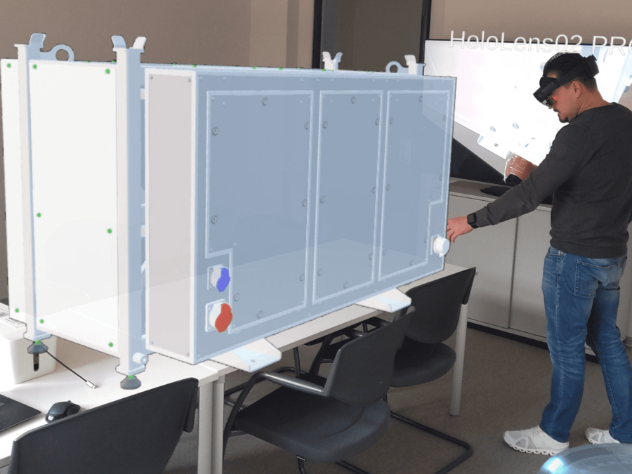 Techniker mit AR-Brille interagiert mit virtueller Darstellung einer Wartungsanlage bei der Inspektion
